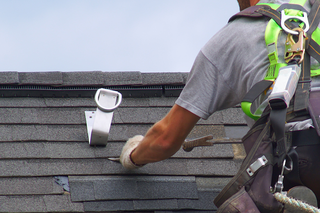 Roofing crew installing new shingles on a home